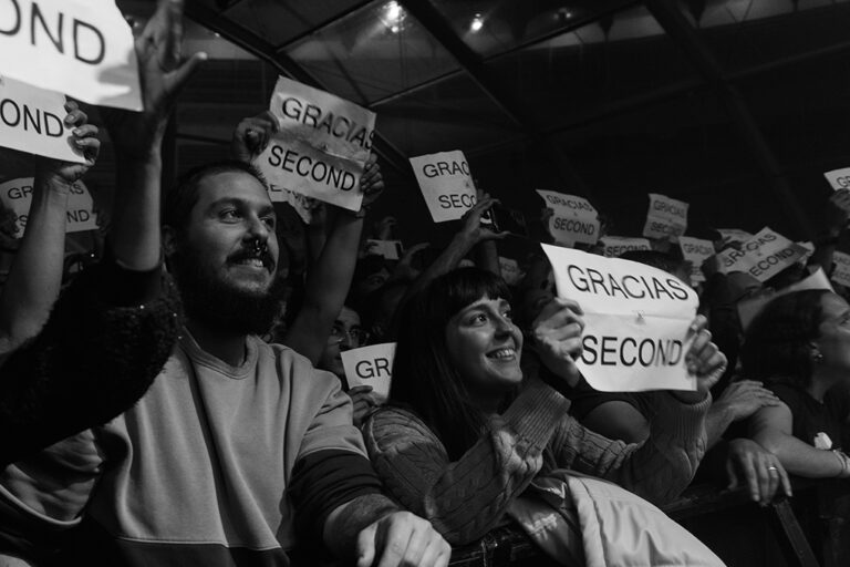 Público portando un cartel donde se lee: "Gracias Second"