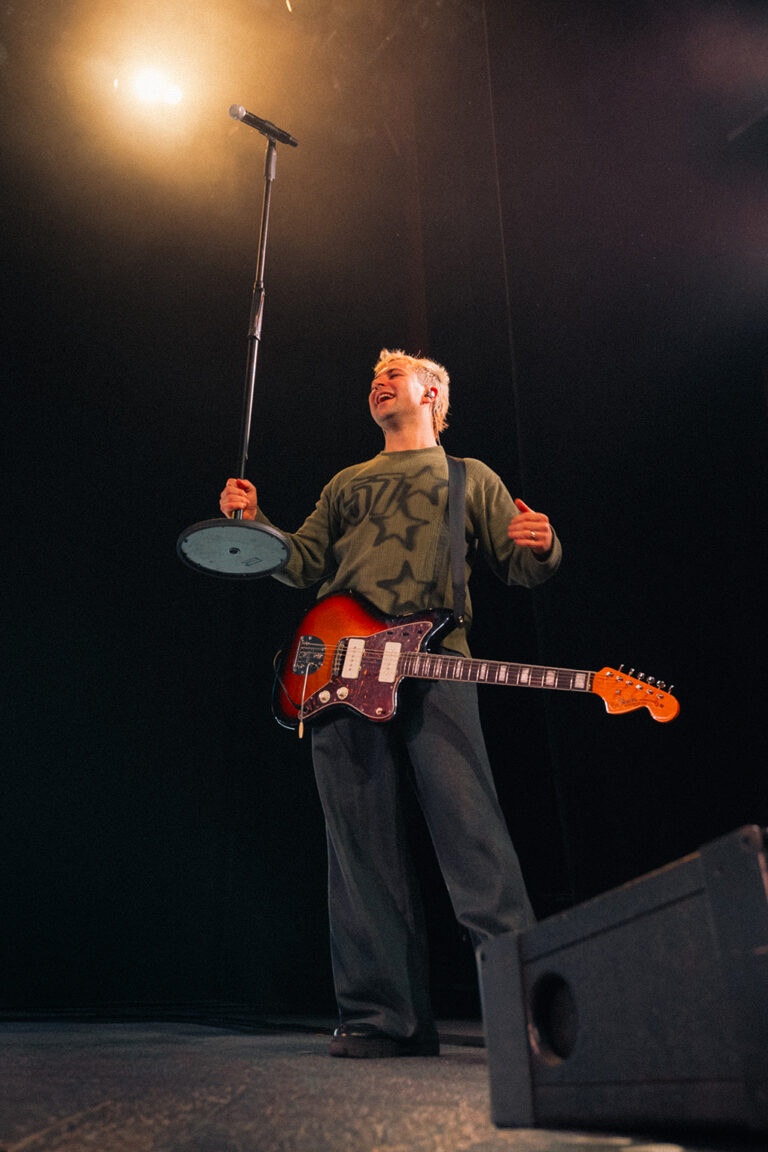 Miembro de Besmaya con el micrófono en alto apuntando al público