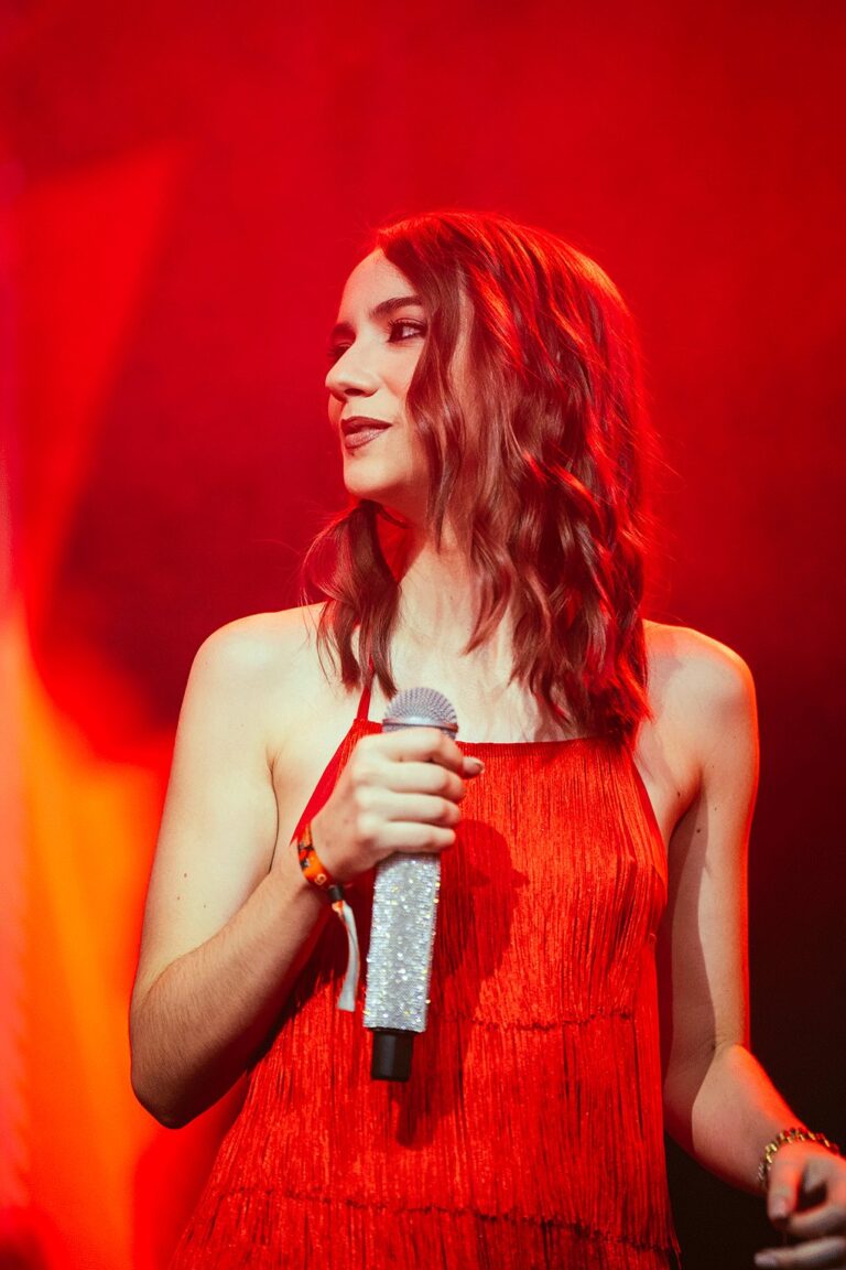 Alicia Padilla mirando hacia su izquierda con el micrófono en la mano