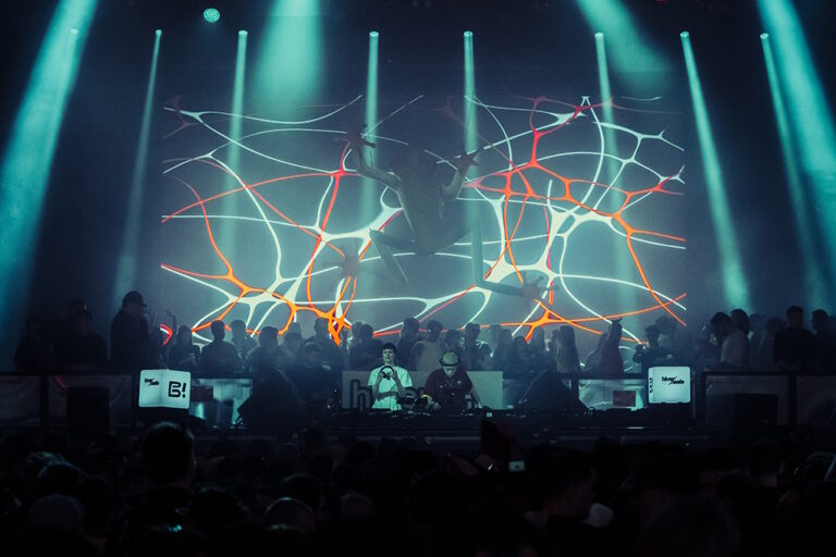 Escenario iluminado en colores verdes, rojos y amarillos en Hivernacle Tribe