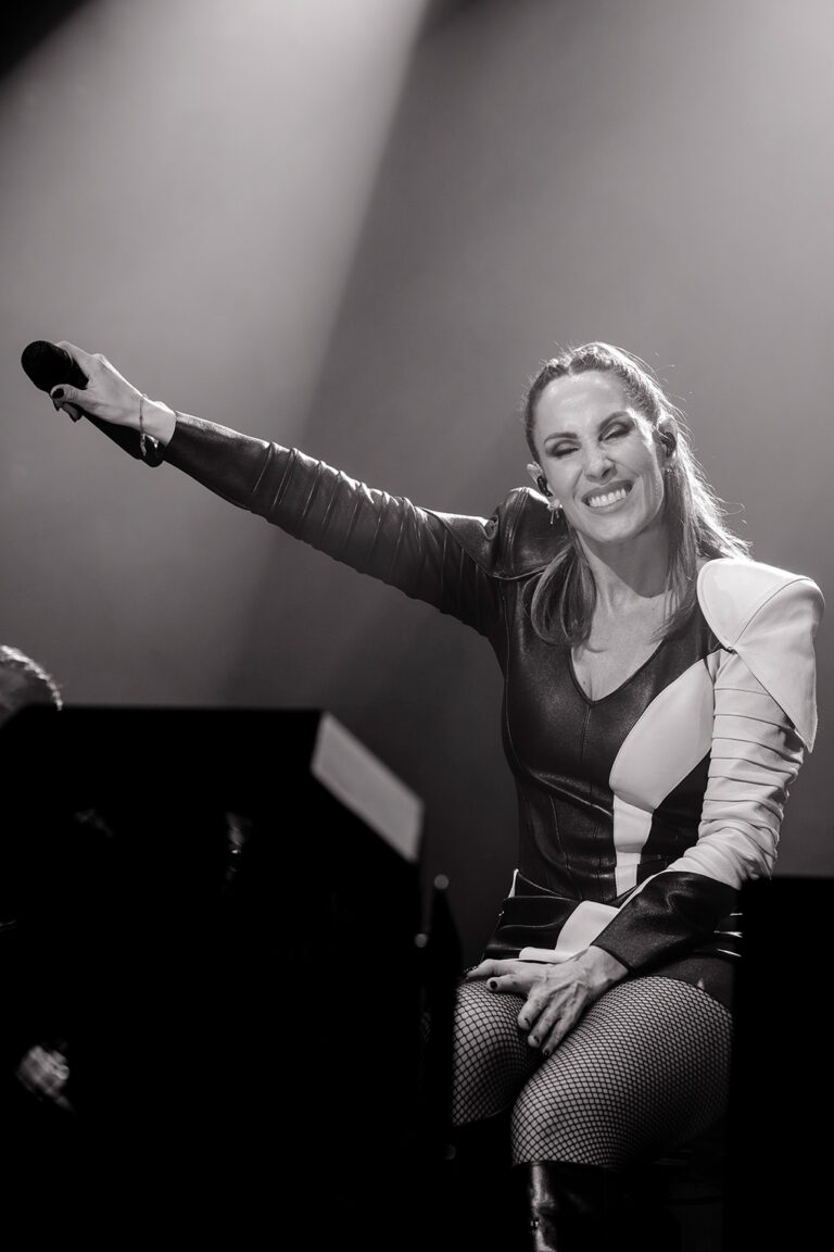 Malú con el micrófono apuntando al público